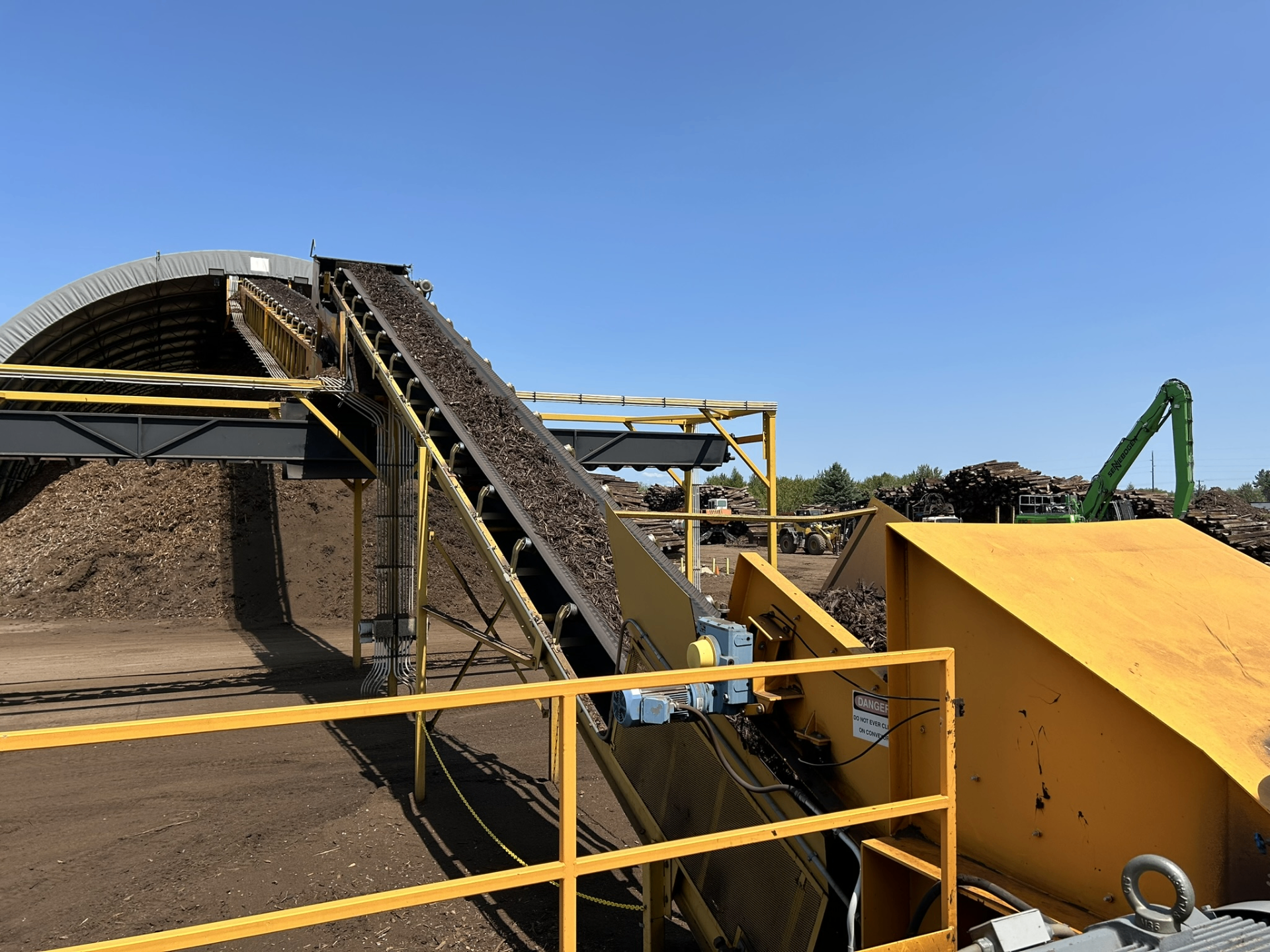 Staack Energy biomass processing facility with conveyor and chip pile